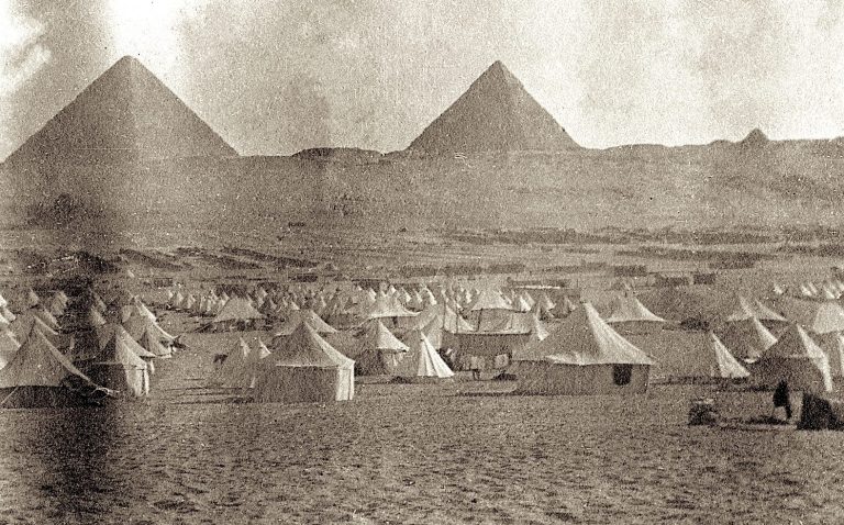 Tents set up near the pyramids of Giza in a historical setting.