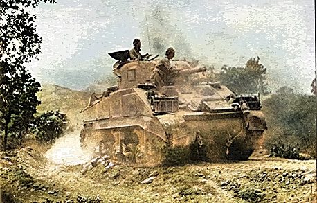A military tank driving through a rugged, dusty landscape.
